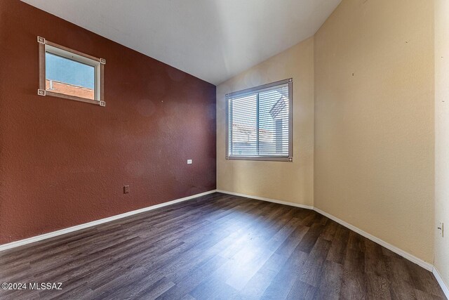 unfurnished bedroom featuring hardwood / wood-style floors, vaulted ceiling, and a closet