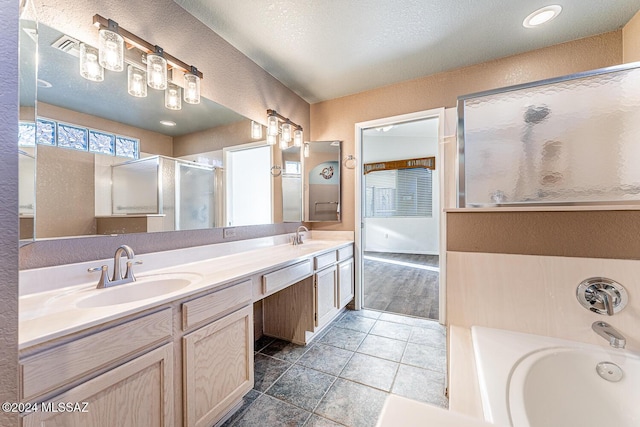 bathroom with vanity, separate shower and tub, and a textured ceiling