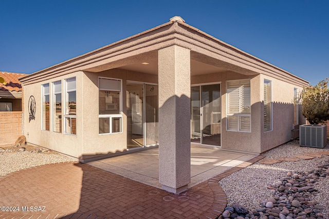 rear view of property featuring cooling unit and a patio area