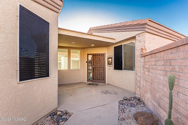 1307 W Mariquita St, Green Valley, AZ 85622 - view of exterior entry with stucco siding and a patio