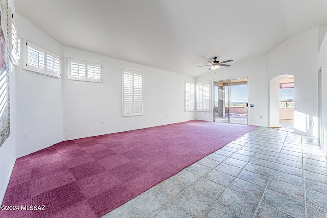 carpeted empty room featuring ceiling fan and vaulted ceiling