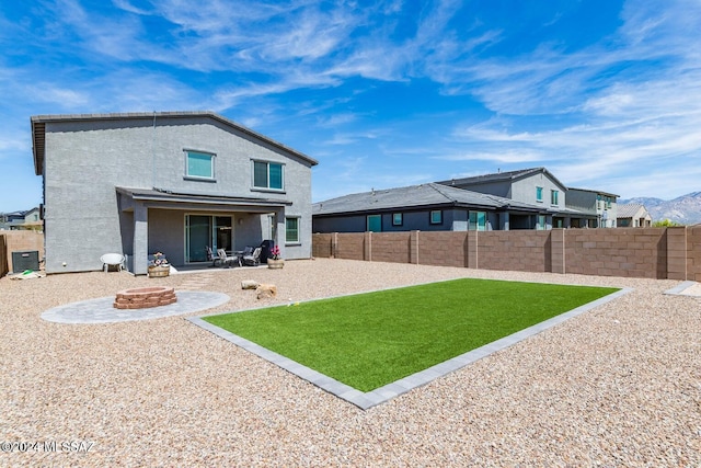 rear view of property featuring central air condition unit, a fire pit, a patio area, and a lawn