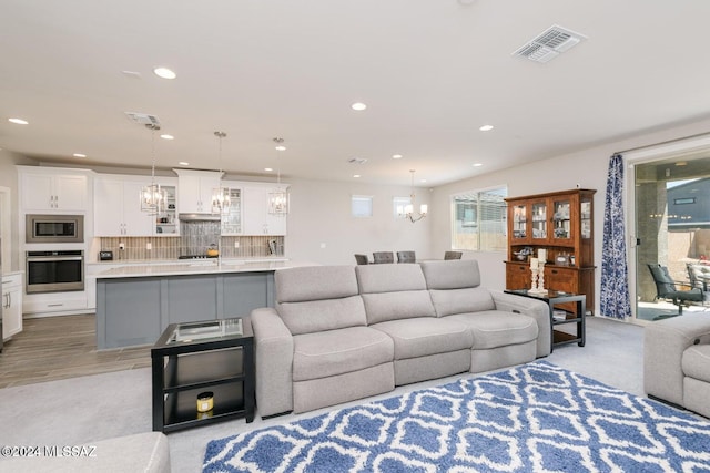 living room featuring light hardwood / wood-style floors and an inviting chandelier