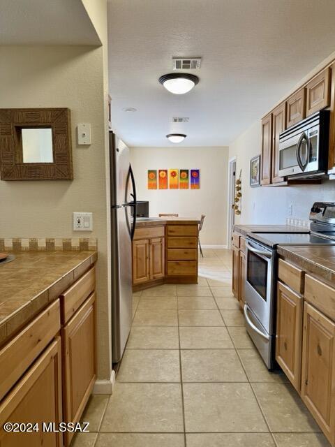 kitchen with light tile patterned floors and appliances with stainless steel finishes