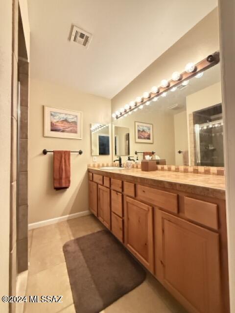 bathroom with tile patterned flooring, vanity, and a shower with shower door