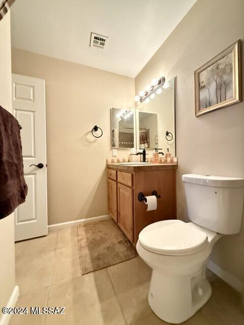 bathroom featuring tile patterned flooring, vanity, and toilet