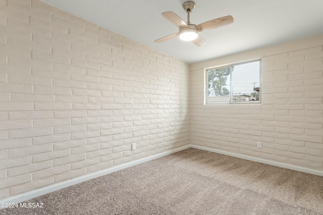 carpeted spare room featuring brick wall and lofted ceiling