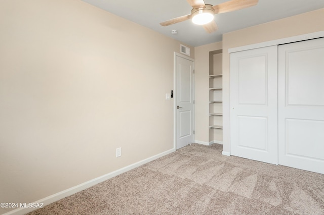 unfurnished bedroom featuring ceiling fan, a closet, and light colored carpet