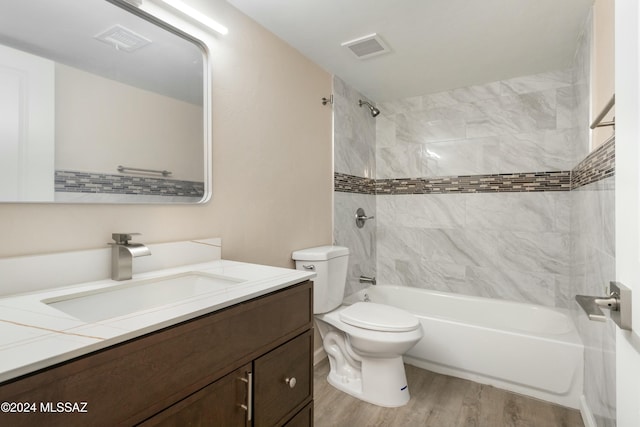 full bathroom featuring vanity, toilet, wood-type flooring, and tiled shower / bath