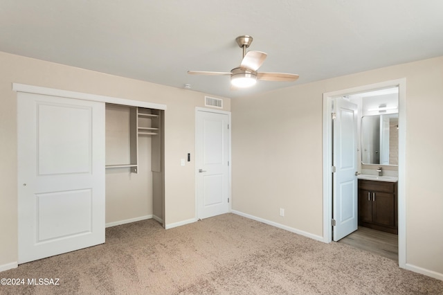 unfurnished bedroom with ceiling fan, a closet, light colored carpet, and sink