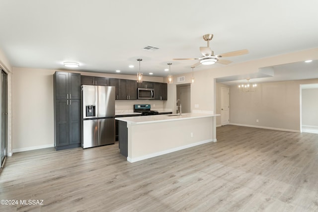 kitchen with light wood-type flooring, stainless steel appliances, dark brown cabinetry, and an island with sink