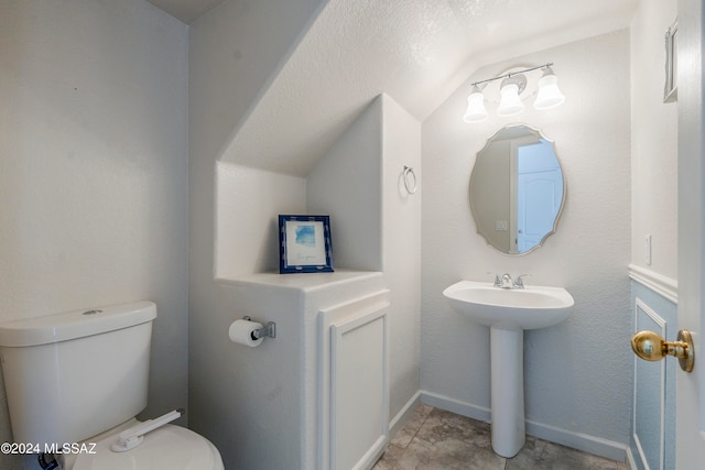 bathroom with sink, vaulted ceiling, and toilet