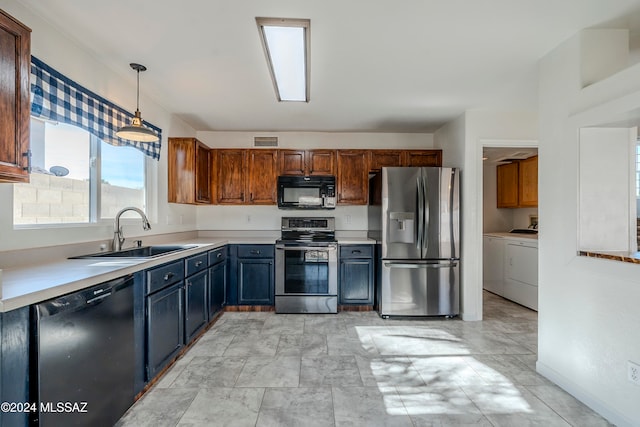 kitchen featuring washer and dryer, pendant lighting, sink, and black appliances