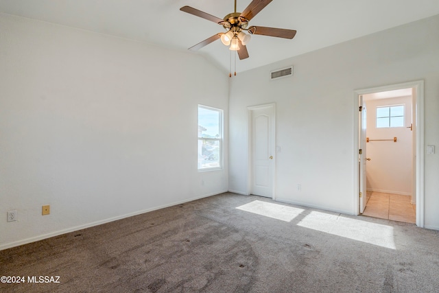 unfurnished bedroom featuring ensuite bath, ceiling fan, light carpet, and lofted ceiling