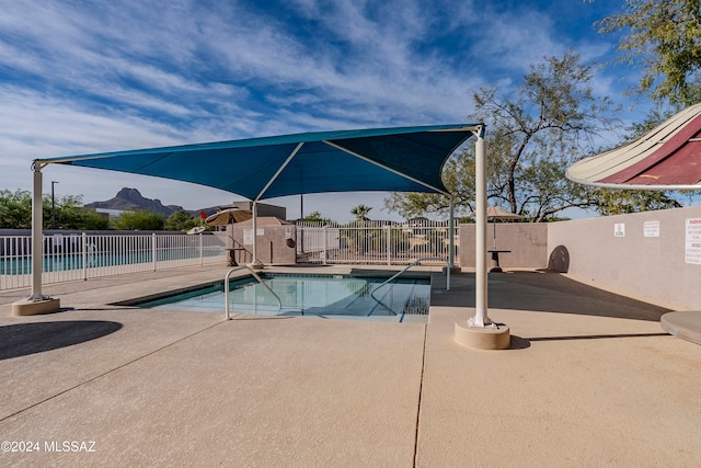 view of swimming pool with a mountain view and a patio area