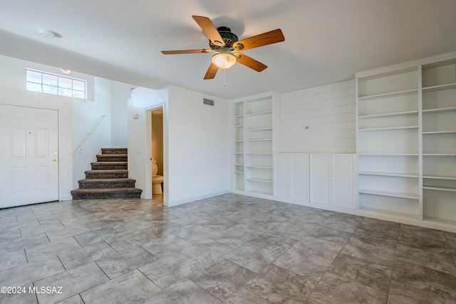 unfurnished living room with ceiling fan and built in features