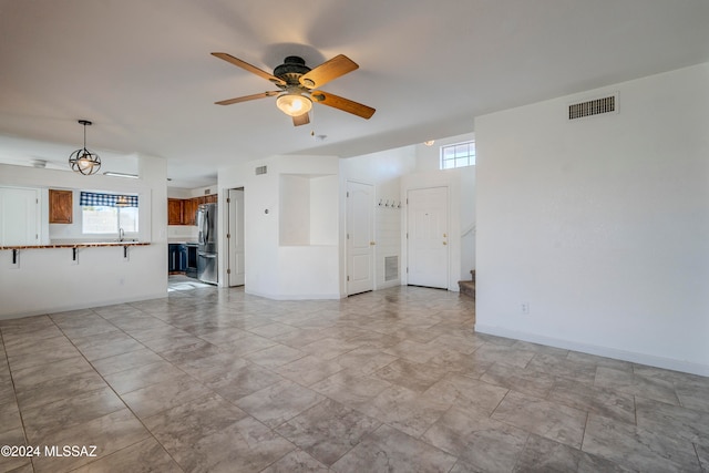 unfurnished living room featuring sink, a wealth of natural light, and ceiling fan