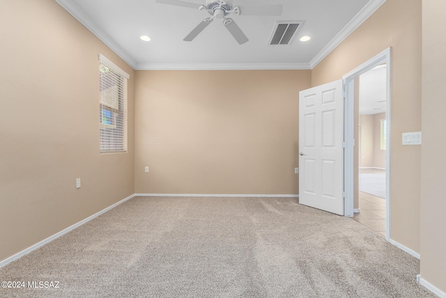 spare room with ceiling fan, ornamental molding, and light carpet