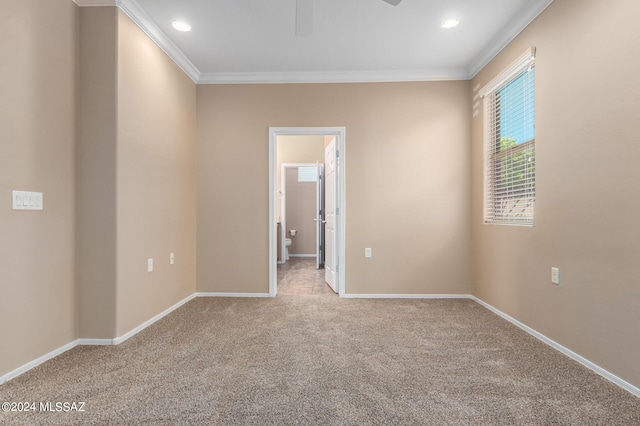 carpeted empty room featuring crown molding