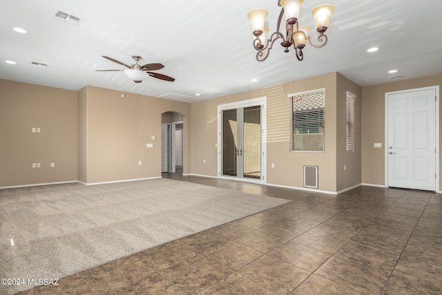 unfurnished living room featuring ceiling fan with notable chandelier and french doors