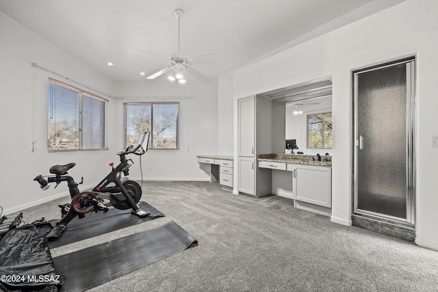 exercise area with carpet flooring, ceiling fan, plenty of natural light, and built in desk