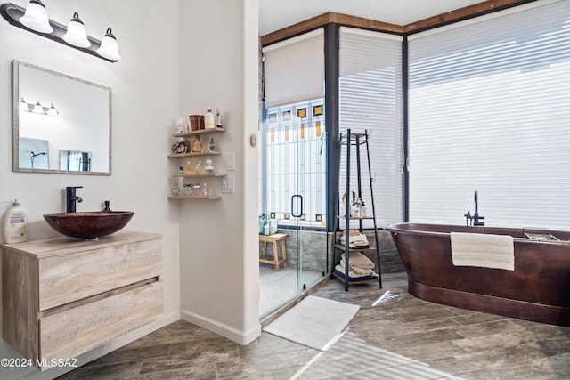 bathroom with plus walk in shower, plenty of natural light, and vanity