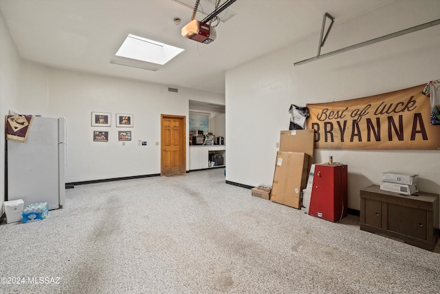 garage featuring white fridge and a garage door opener