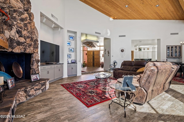 living room featuring wood ceiling, wood-type flooring, a fireplace, and high vaulted ceiling