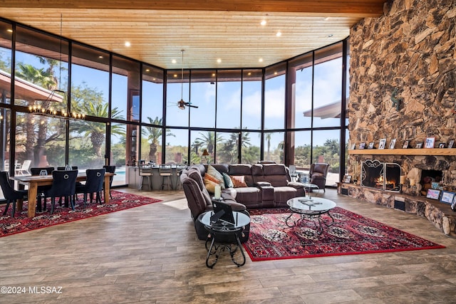 living room with floor to ceiling windows, hardwood / wood-style flooring, a fireplace, beamed ceiling, and wood ceiling