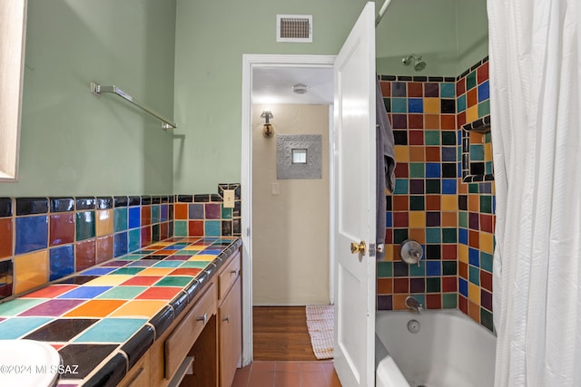 bathroom with shower / tub combo with curtain, vanity, and tile patterned flooring