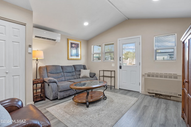 living room with lofted ceiling, an AC wall unit, radiator heating unit, and light hardwood / wood-style flooring