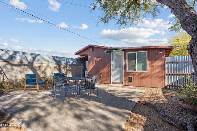 rear view of property with a patio area, an outdoor structure, and a deck