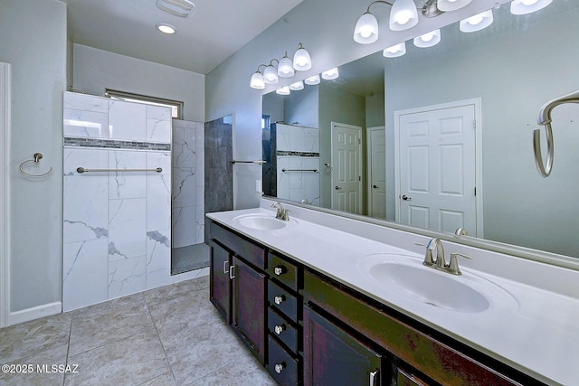 bathroom with a tile shower and vanity