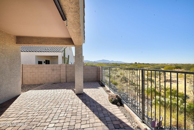 view of patio featuring fence and a mountain view