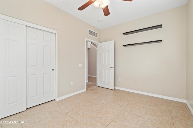 unfurnished bedroom featuring ceiling fan, a closet, and light tile patterned floors