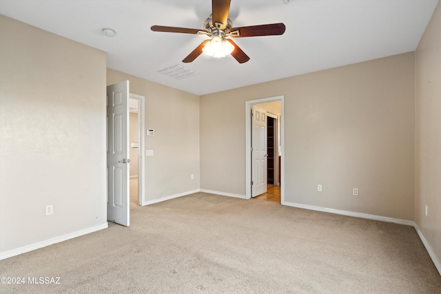 spare room featuring light carpet and ceiling fan