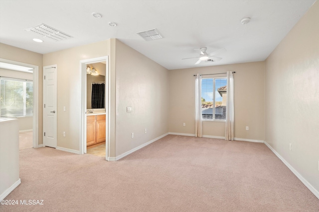 spare room featuring light colored carpet and ceiling fan