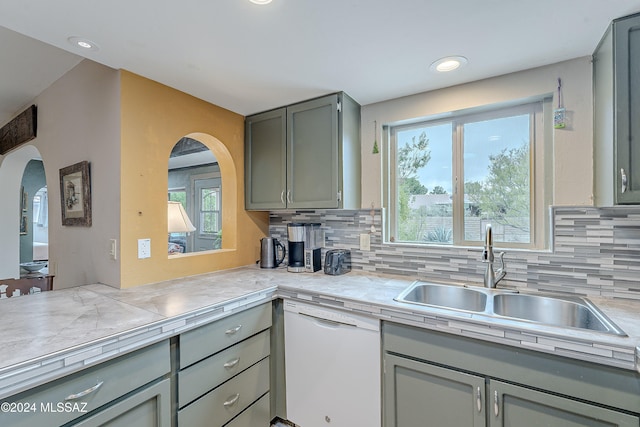 kitchen with dishwasher, gray cabinets, sink, and tasteful backsplash