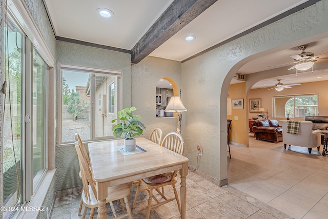 tiled dining space with beam ceiling, ceiling fan, and crown molding