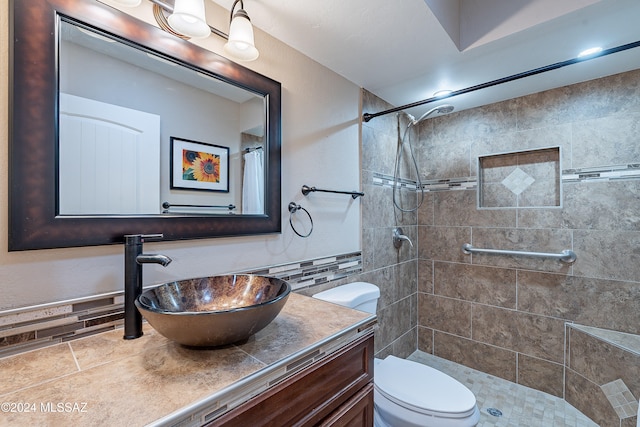 bathroom with decorative backsplash, toilet, walk in shower, and vanity