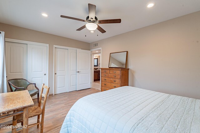 bedroom featuring multiple closets, ceiling fan, and light wood-type flooring