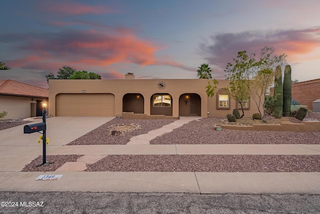 pueblo revival-style home featuring a garage