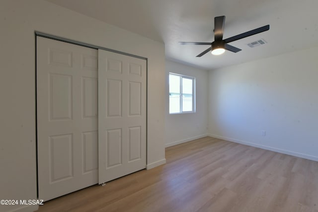 unfurnished bedroom featuring ceiling fan, a closet, and light hardwood / wood-style floors