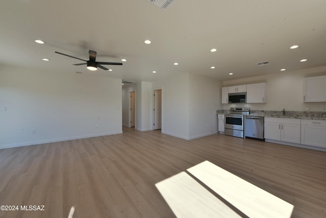 kitchen with sink, ceiling fan, light wood-type flooring, appliances with stainless steel finishes, and white cabinetry