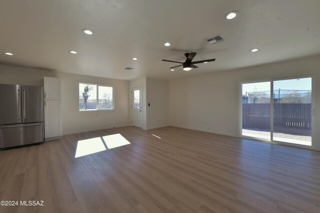 unfurnished living room featuring ceiling fan and hardwood / wood-style flooring