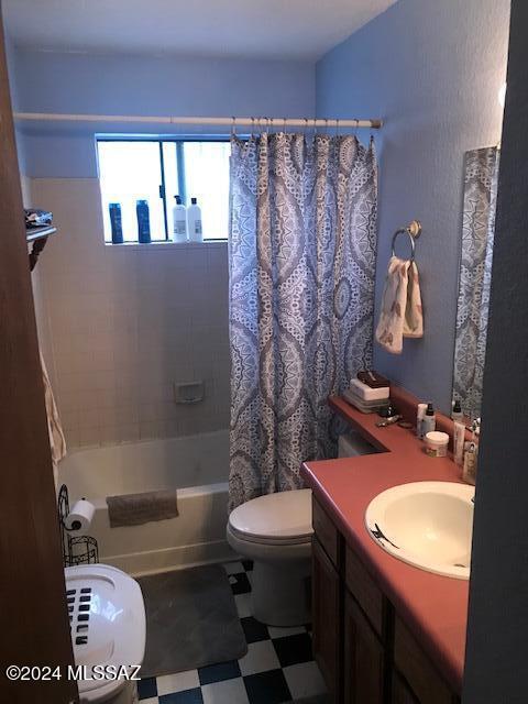 full bathroom with shower / bath combo with shower curtain, vanity, and toilet