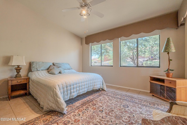 bedroom with ceiling fan, light tile patterned floors, and vaulted ceiling