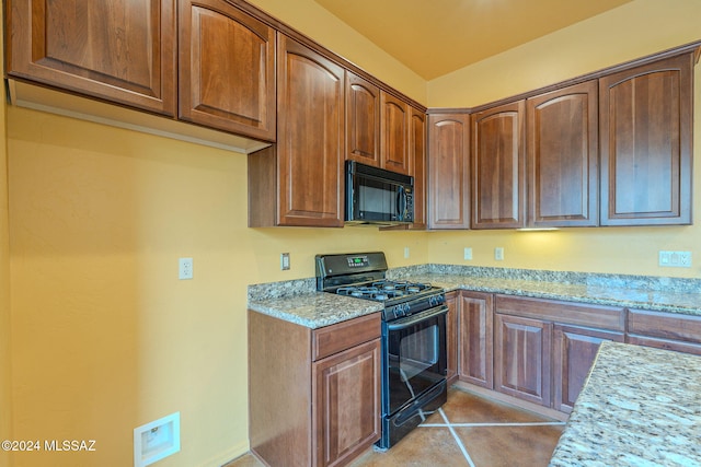 kitchen with black appliances, light stone countertops, and light tile patterned floors