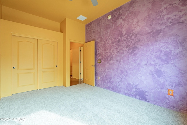 unfurnished bedroom with carpet flooring, a closet, and ceiling fan