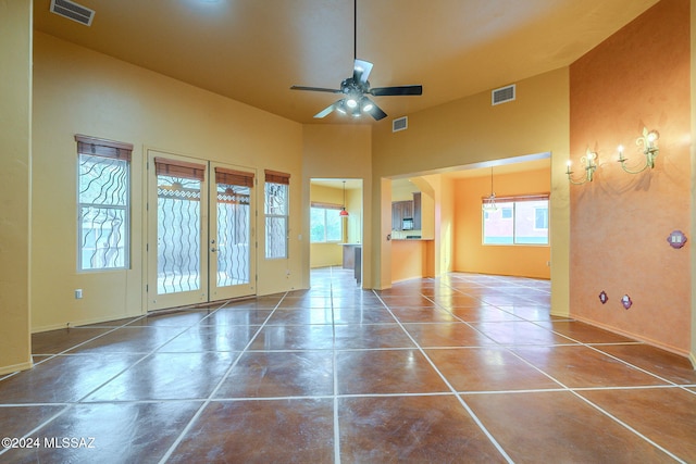 tiled empty room with ceiling fan and french doors